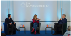 Fotoausschnitt aus Youtube mit dem Moderator Zackes Brustik, Maja Göpel und Reinhard Schneider. Im Hintergrund das Logo "Die Zuversichtlichen"